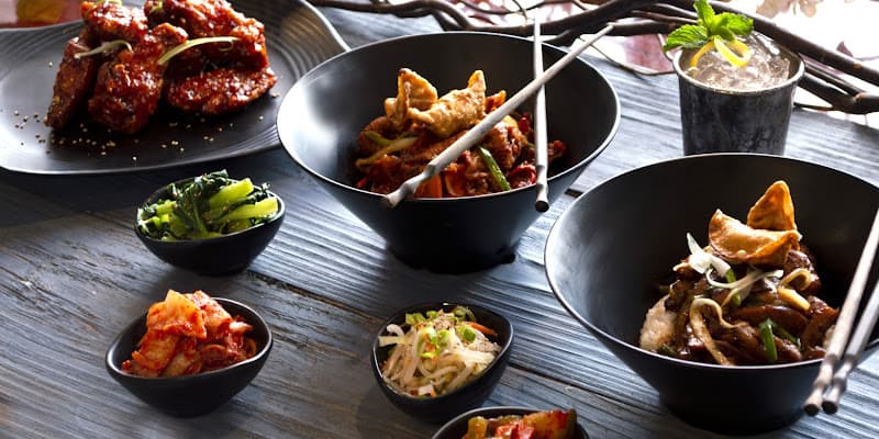 Editorial overhead of a full Matjoa House table spread with grilled meats, banchan, and drinks