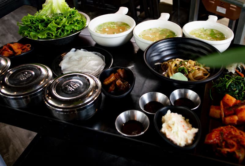 Fresh ssam station at Matjoa House with lettuce leaves, perilla, rice, and banchan set up for wrapping